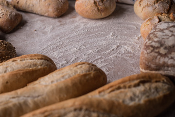 Tradycyjny chleb i bułki na zakwasie z szorstką skórką na rustykalnym drewnianym stole.  - obrazy, fototapety, plakaty