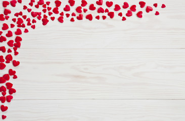 Red heart symbols on a white wooden background. Top view, background. Concept for wedding, engagement, valentine's day and other romantic holidays and events