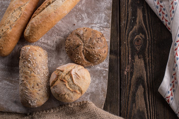 Chleb i bułki na drewnianym tle © Olo