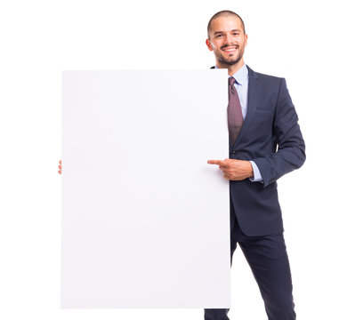 Portrait of happy smiling young businessman pointing to blank board