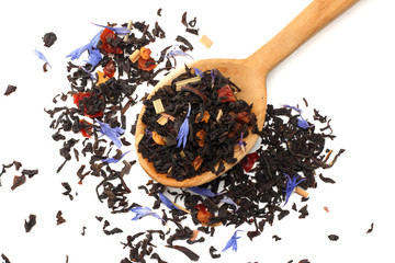 Aromatic black dry tea with petals in wooden spoon isolated on white background