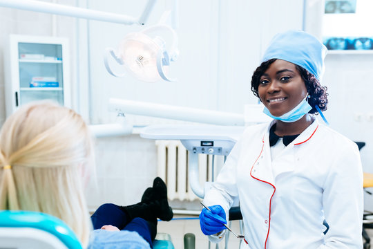 African american female dentist treating patient at clinic. Dental clinic concept.