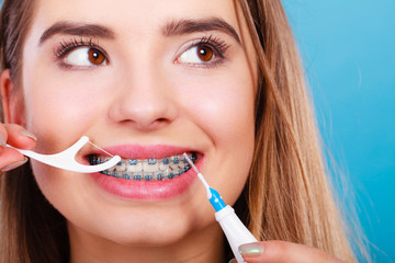 Woman with braces cleaning teeth with toothbrush