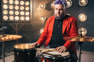 Bearded drummer in red suit, vintage style