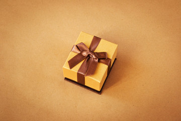 Beautiful golden gift box on wrapping paper background