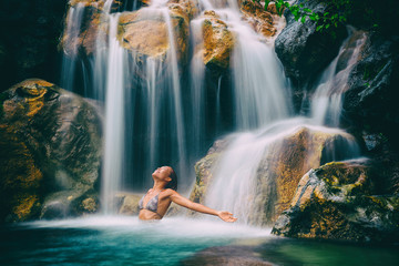 Wellness spa waterfall woman with open arms in freedom relaxing in nature waterfall. Relaxation in paradise tropical vacation. Hawaii holiday destination.