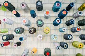 Colorful threads on spools closeup, side view