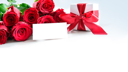 Bouquet of red roses and gift box with empty tag