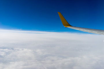Clouds and wing, view from the window of airplane flying in the clouds