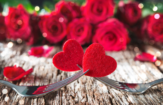 Hearts on forks in front of red roses