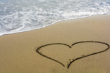 Obraz na płótnie Canvas A heart in the sand on a beach with free space for text