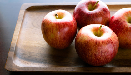 Delicious red apples on wooden tray