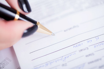 Business woman signing a contract above signature line