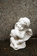 Little angel with heart figure on a grave. Memory of darlings.