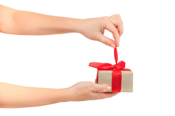female hands untie the red ribbon and open the gift.  gift your loved one