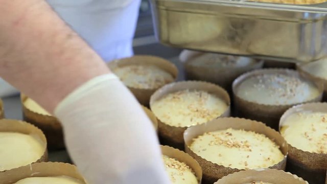 pastry chef hands put almonds and nuts grains on dough for easter cake sweet brade