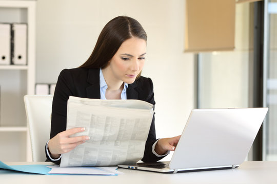 Businesswoman working reading a newspaper