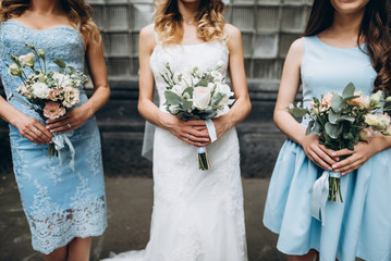 Wedding. The bride in a white dress is standing with her bridesmaids which are in pastel blue...