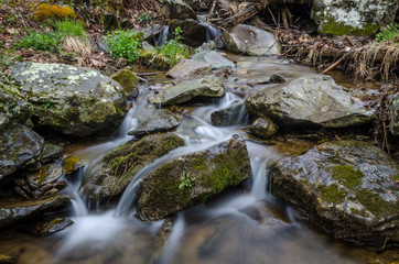quiet serene stream flowing around large rocks