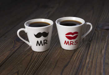 Two cups with a hot drink of lovers, mr and mrs, man and woman. Holiday, St. Valentine's Day, lovers' day, anniversary.
