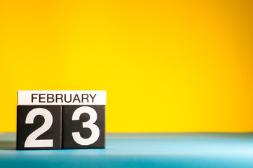 February 23rd. Day 23 of february month, calendar on yellow background. Winter time. Empty space for text