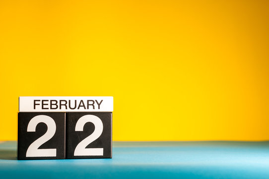 February 22nd. Day 22 of february month, calendar on yellow background. Winter time. Empty space for text