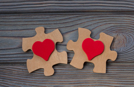 two pieces of a puzzle with a red heart, unite into a single whole. Holiday, St. Valentine's Day, lovers' day, close-up