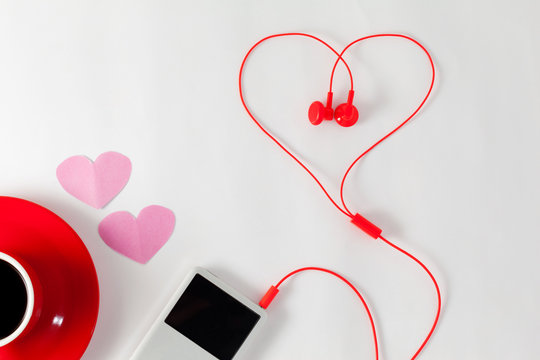 Red coffee cup with music player and red earphone on white background,Valentine's day concept.