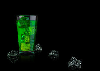 Green energy soda drink glass with ice cubes