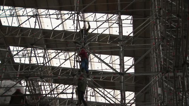 People working on the builders metal scaffolding. Construction of buildings and structures
