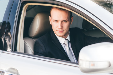 Handsome businessman in suit in a car