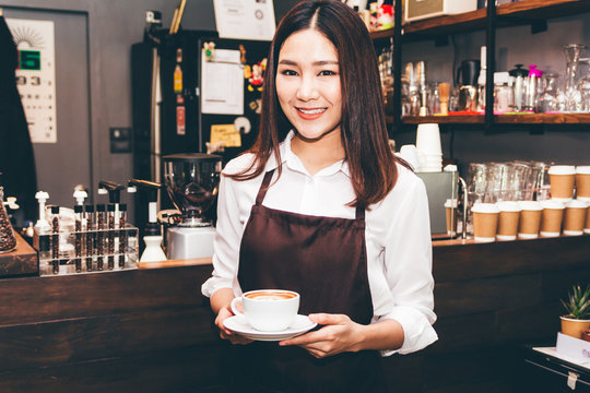 Barista holding coffee in coffee shop