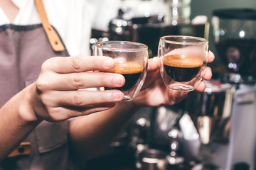 Woman barista giving coffee to customer at cafe