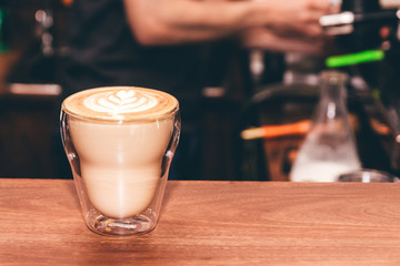Coffee latte art on wooden table in coffee shop