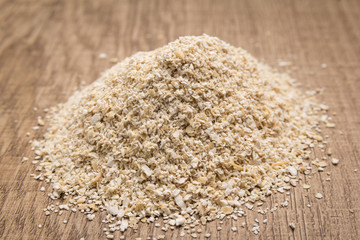Oat cereal grain. Pile of grains on the wooden table. Selective focus.