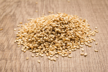 Sesame. Pile of grains on the wooden table. Selective focus.