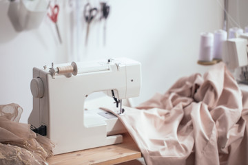 Sewing machine on table in tailor workshop