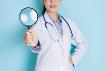 smiling young doctor standing in blue background