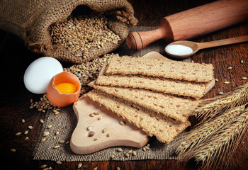 crispbread and ingredients, eggs, flour on rustic wooden table