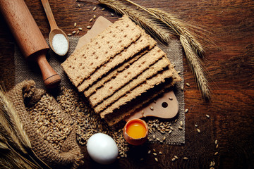 crispbread and ingredients, eggs, flour on rustic wooden table