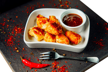 Chicken Nuggets impaled on a fork in ketchup closeup