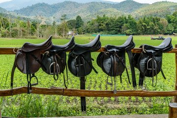 Saddle on wooden fence