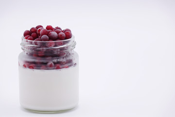 Fresh berries in the jar with the yogurt. On white background.