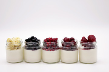 Fresh berries in the jar with the yogurt. On white background.