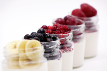 Fresh berries in the jar with the yogurt. On white background.