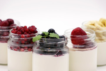 Fresh berries in the jar with the yogurt. On white background.