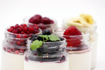 Fresh berries in the jar with the yogurt. On white background.