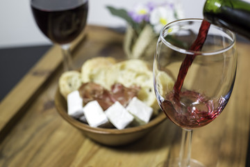 Red wine in a glass and a set of products -cheese, salami, and bread