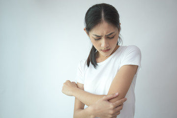 Woman touching her elbow with hands. Young asian woman feel pain in her elbow. isolated on withe background.
