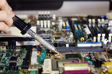 Soldering to a circuit Board of a computer close up.